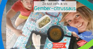 2 vrouwen zitten aan tafel waarop een maaltijd met vis staat