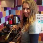 vrouw roert in pan met ghee. ze lacht naar de camera