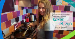 vrouw roert in pan met ghee. ze lacht naar de camera