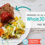 Bord met een portie Whole30 meatloaf, wat zoete aardappels en salade
